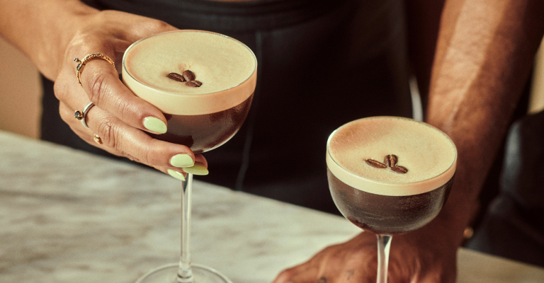 Two people holding espresso martini cocktails